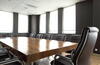 a chair at the end of a long meeting room table